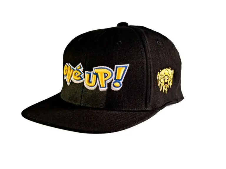 A black wool snapback baseball cap with embroidered Anime style One Up logo and gold mushroom smiley face.