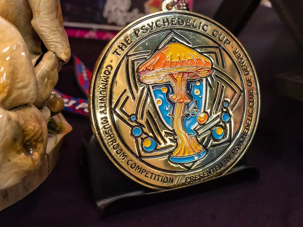 close up of gold metal for first place in The Psychedelic Cup Mushroom Contest.