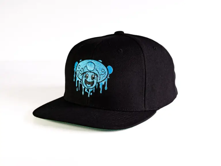 Black flat billed. snapback cap with embroidered One Up logo and blue mushroom smiley face on it.