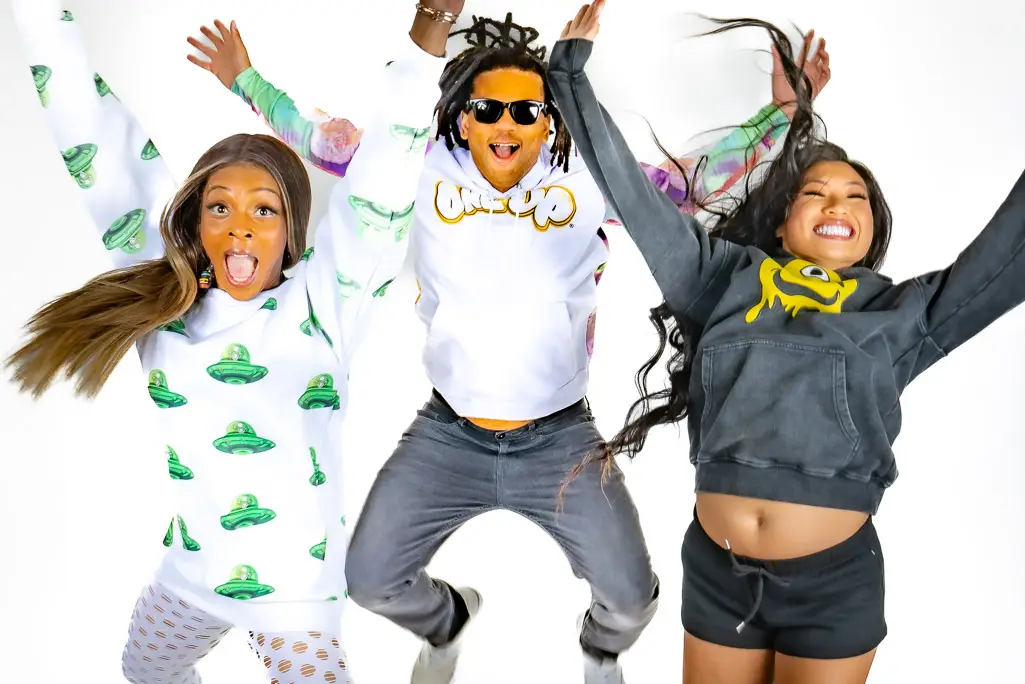 2 girls and 1 boy jumping for joy, and wering all new One Up apparel Hoodies and sweatshirts.